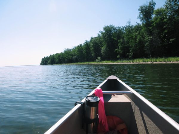 Canoe on blue lake with forest