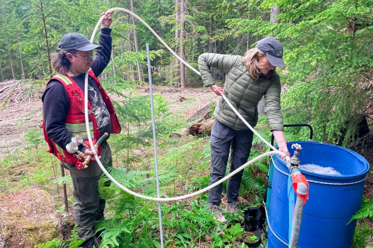 The Living Lakes team measures standpipe flow. LLC Photo