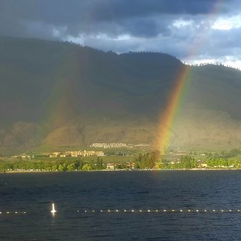 A double rainbow touches down on the far side of the lake after the passing of a thunderstorm.