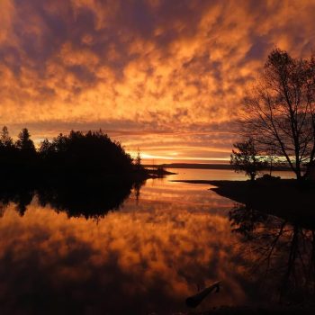 Clouds, sunrise and reflective water combine to create early morning magic over a small inlet of Georgian Bay.