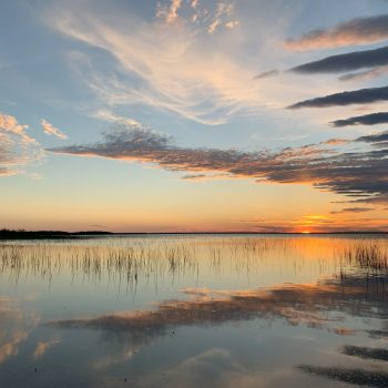 A moment of reflection during an iconic Northern Manitoba sunset over a calm lake.