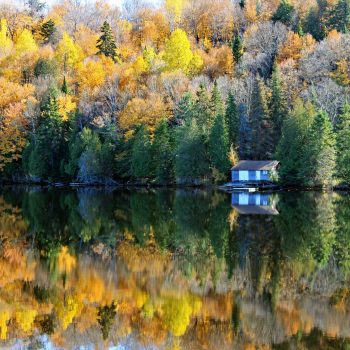 Une petite maison sur lac en automne.