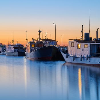 The sun begins to rise over fishing vessels, having returned from their summer season to be prepped for the long Manitoba winter. .