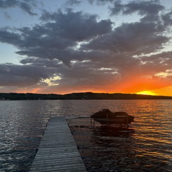 A cloudy sunset on Katepwa Lake, Saskatchewan, with orange and yellow reflections on the water.