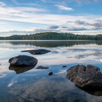 The morning fog lifts to reveal the underlying reflections of early morning clouds on Silent Lake.