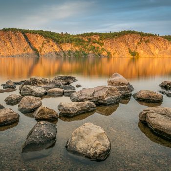 Warm hues of a setting summer sun on the 100 meter high Mazinaw Rock. With over 260 pictographs, we are reminded of the inextricable weaving of lake biodiversity and indigenous culture and what we can ...